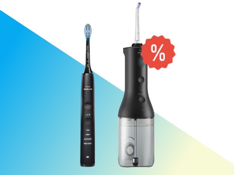 Schwarze Philips Sonicare neben schwarz silbernes größeres Gerät auf weißem Hintergrund mit blau gelben Farbverlauf unten und rotem Prozentzeichen rechts oben