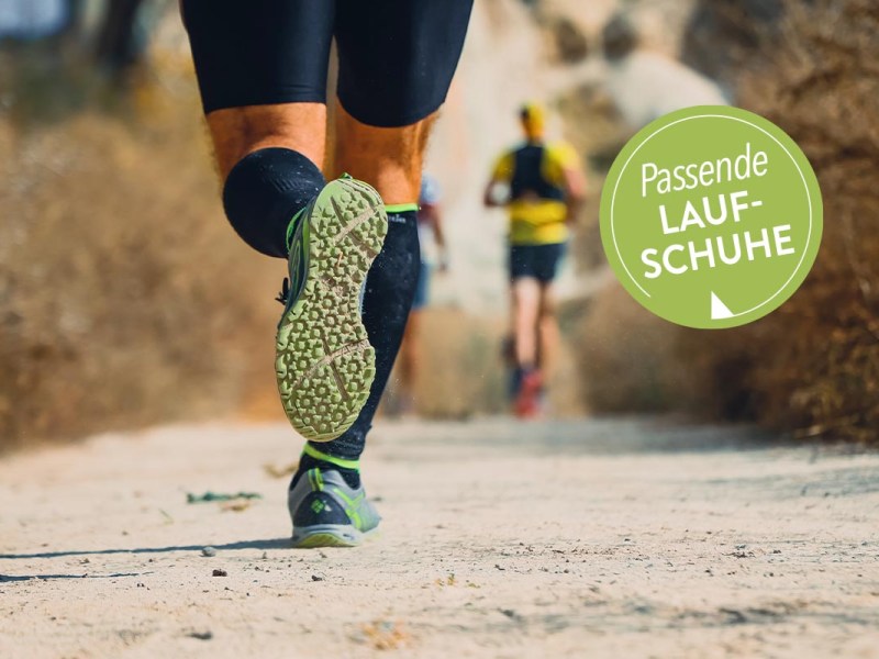 Zwei Personen laufen in Sportschuhen auf Sandweg.