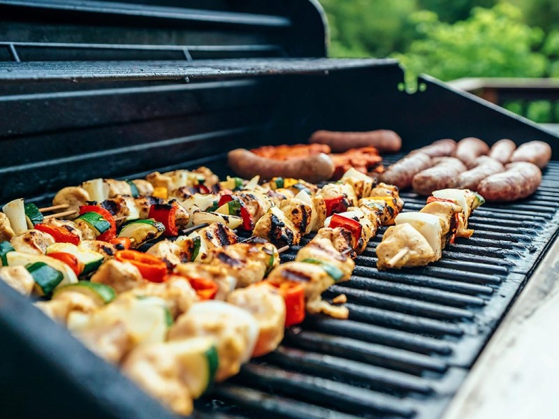 Gemüse und Fleisch auf einem Grill.